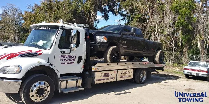 Universal Towing flatbed hauling heavy equipment